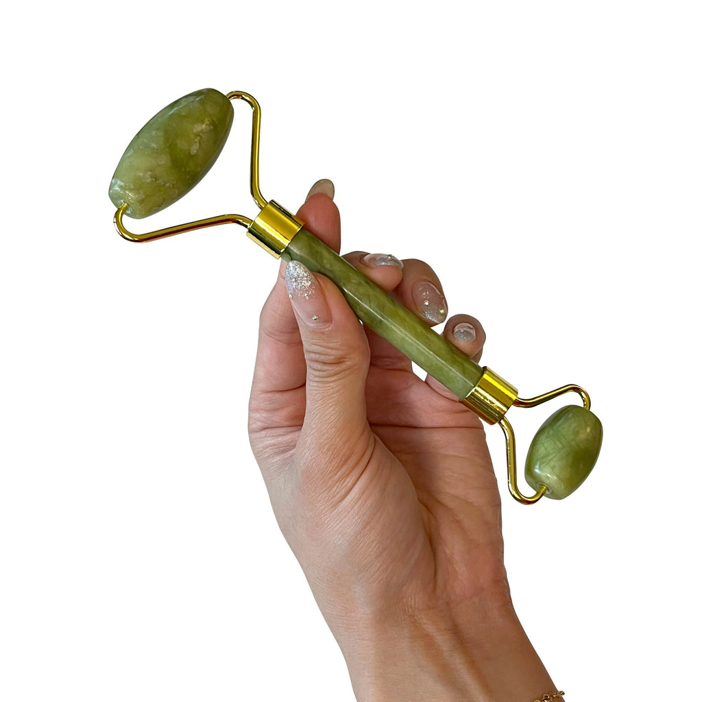 Hands holding jade roller for facial massage and circulation